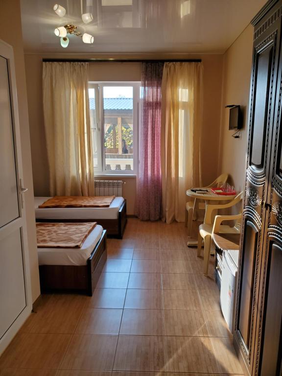 ロオにあるГорное Ущелье "Gornoe Uschelye"のベッド2台と窓が備わるホテルルームです。