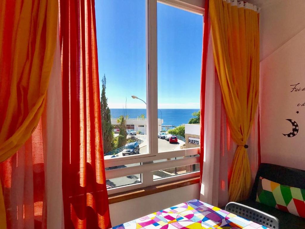 een slaapkamer met een raam met uitzicht op de oceaan bij Ocean View Design Apartment Puerto Rico in Puerto Rico de Gran Canaria