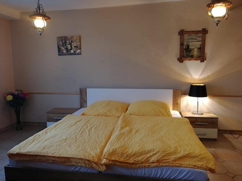 a bedroom with a bed with a yellow comforter at Gasthaus Hochwald in Hattgenstein