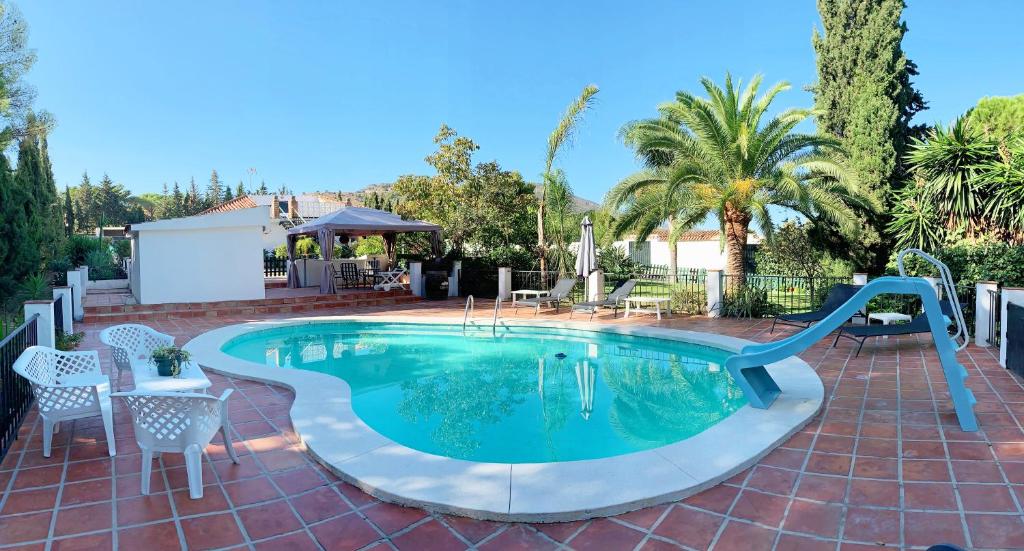 a swimming pool with a slide in a yard at Finca Mi Hogar in Málaga