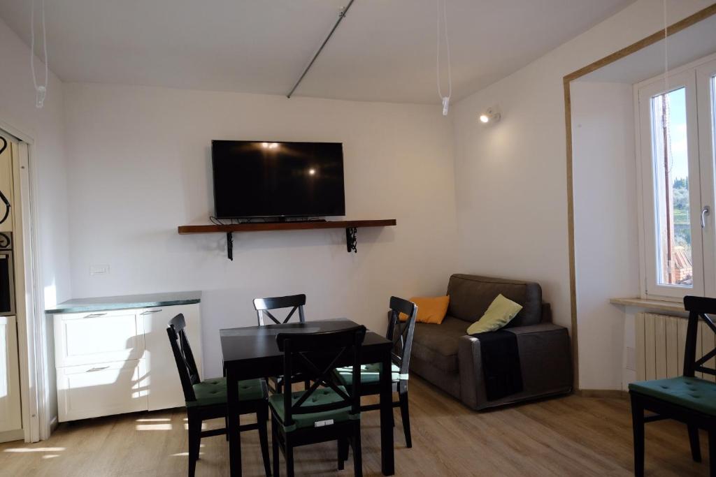 uma sala de estar com uma mesa, um sofá e uma televisão em Il Brigantino em Cori