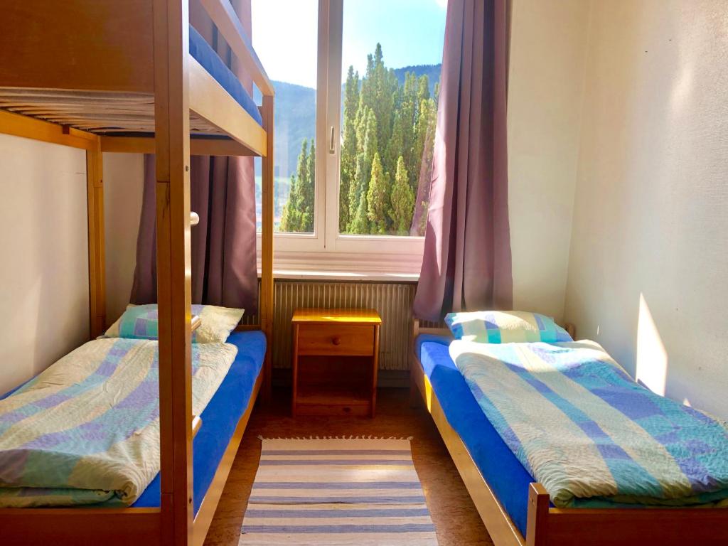 una camera con 2 letti a castello e una finestra di Auberge Pour Tous a Vallorbe