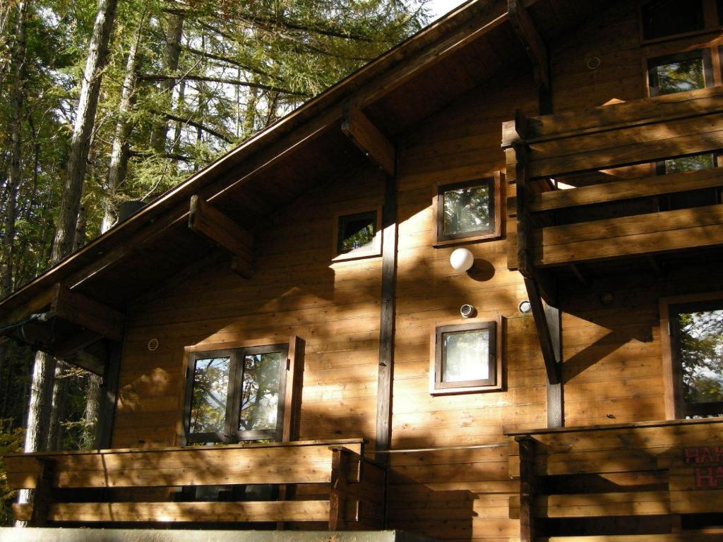 una cabaña de madera en el bosque con árboles en Hayashi Pension, en Hakuba