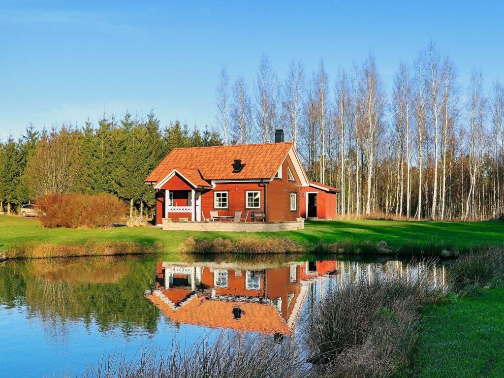 une maison assise sur le côté d'un lac dans l'établissement 6 person holiday home in VITTSJ, à Vittsjö