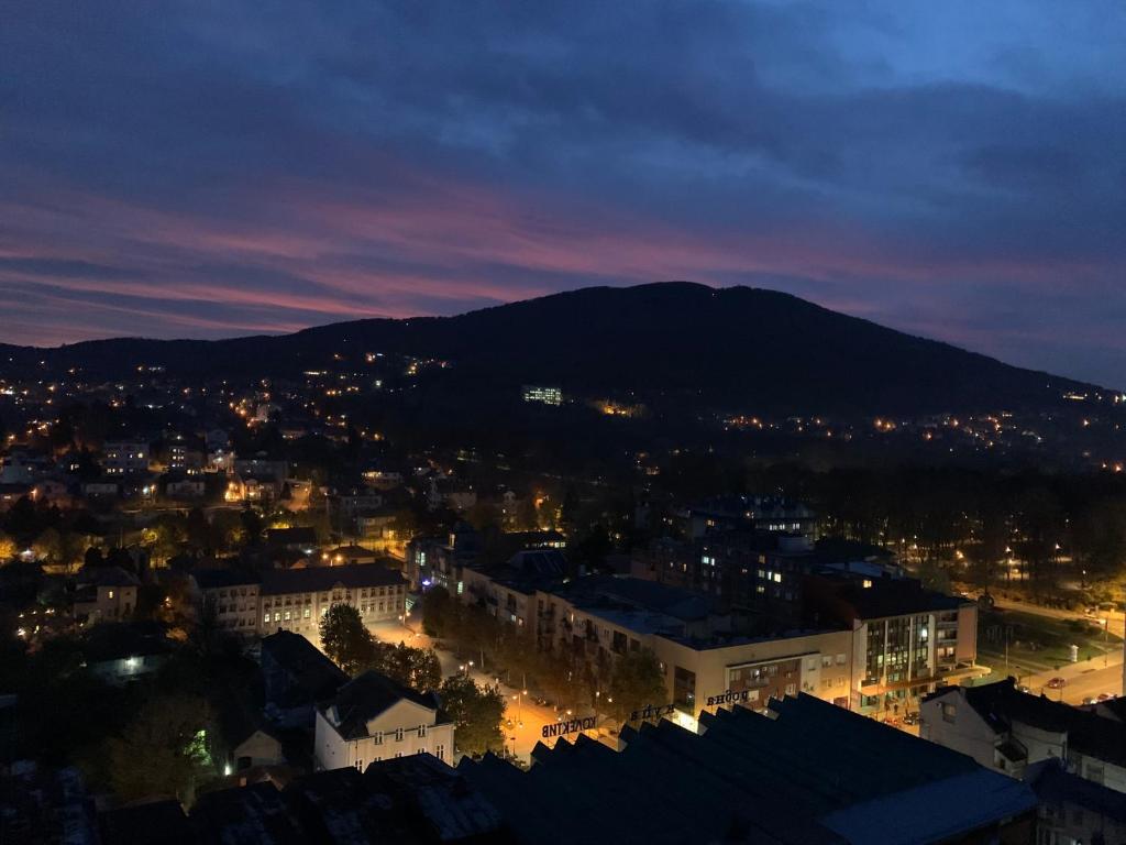 a city at night with a mountain in the background at Simic Apartman in Arandelovac