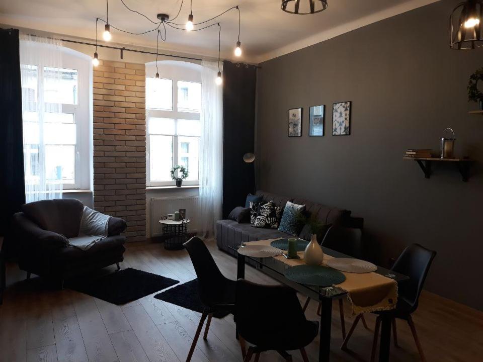 a living room with a couch and a table at Centrum Kupiecka Apartment in Zielona Góra