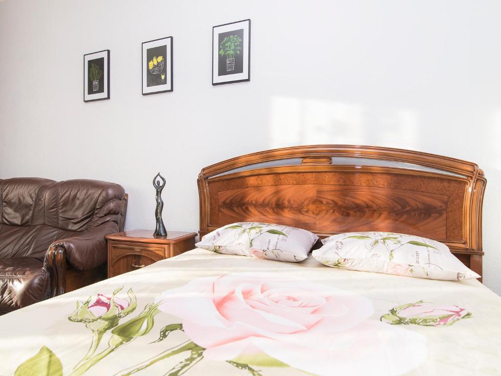 a bed with a flower on it with two pillows at Apartment Tatiana in Yekaterinburg