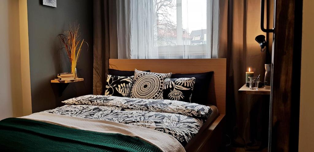 a bedroom with a bed with pillows and a window at Centrum Kupiecka Apartment in Zielona Góra