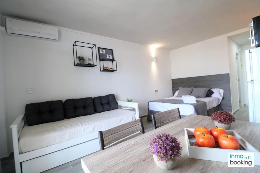ein Wohnzimmer mit 2 Betten und einem Tisch mit Obst in der Unterkunft Experience Internacional Salou - Climatizado con piscina in Salou