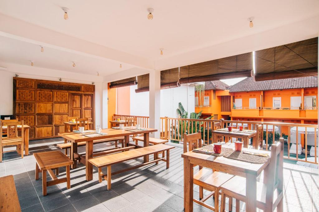 ein leeres Restaurant mit Holztischen und -stühlen in der Unterkunft The Room Padang-Padang in Uluwatu