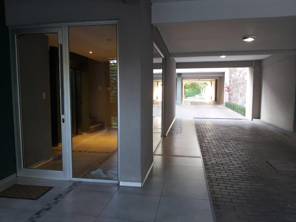 ein leerer Flur eines Gebäudes mit Glastüren in der Unterkunft Linda Vista en Adrogue in Adrogué