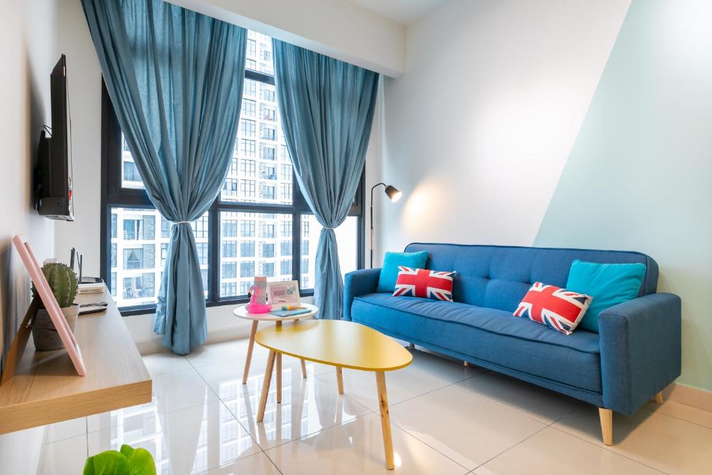 a living room with a blue couch and a table at 28 Boulevard Superior 2 Bedroom Resort Facilities 3-6km to Velocity TRX KLCC in Kuala Lumpur