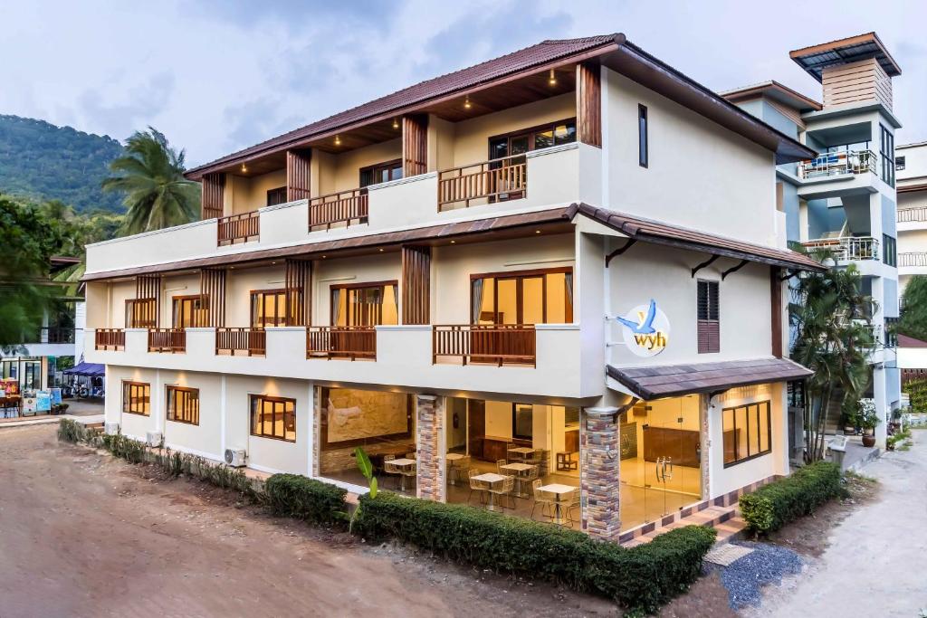 a building with balconies on the side of a street at Wyh Hotels in Koh Tao