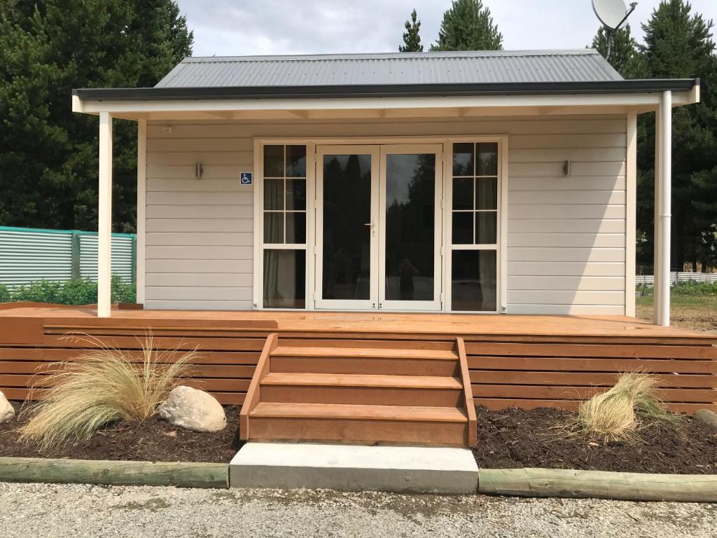 a small house with a wooden deck at Arches Cottage in Twizel