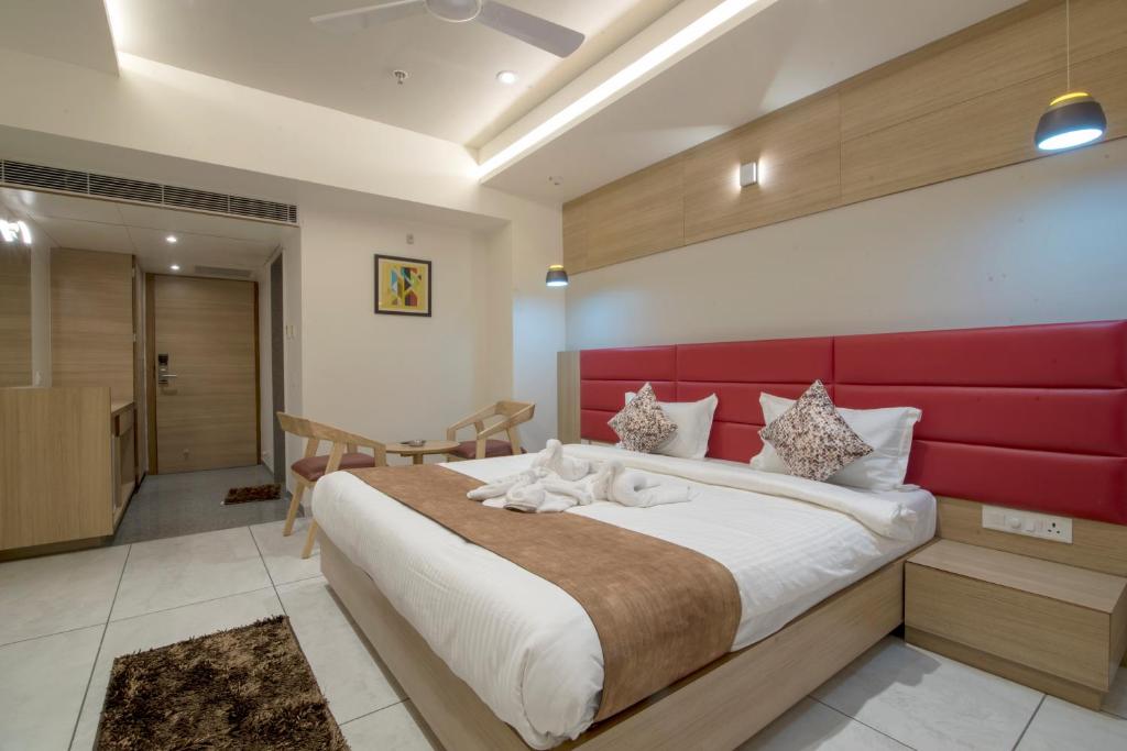 Schlafzimmer mit einem großen Bett mit einem roten Kopfteil in der Unterkunft HOTEL SILVERA GRAND in Ahmedabad