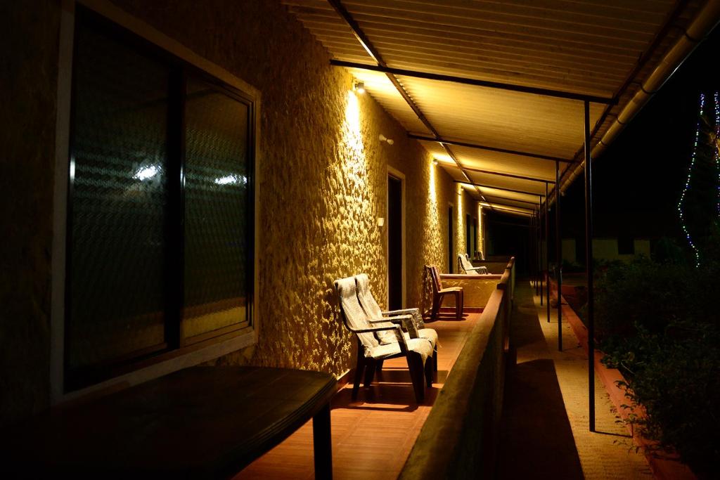 un portico con due sedie e una finestra di notte di jasmine land homestay a Udupi