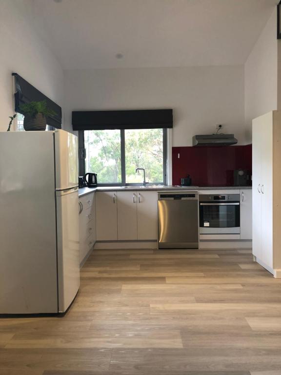 a kitchen with white appliances and a wooden floor at Gully Getaway in Creswick
