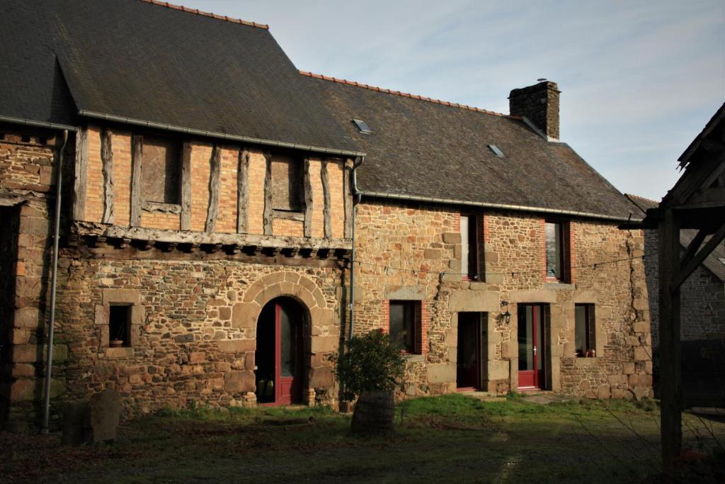 an old stone building with a black roof at La maison à Jean in Val Couesnon