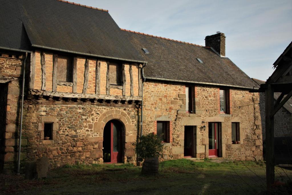 un vecchio edificio in pietra con tetto nero di La maison à Jean a Bazouges-la-Pérouse