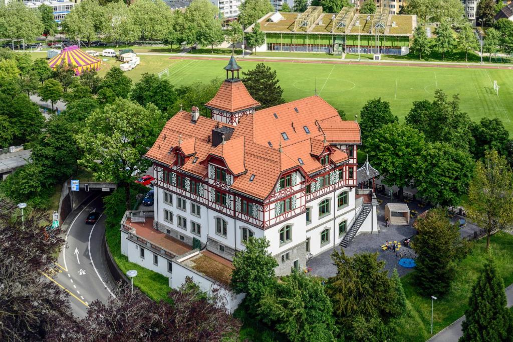 einen Blick über ein großes Gebäude mit orangefarbenem Dach in der Unterkunft Militärkantine St. Gallen in St. Gallen