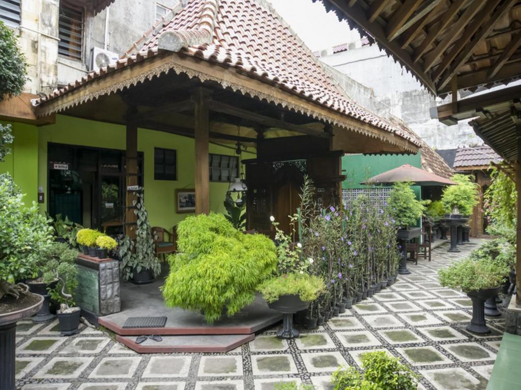 un patio extérieur avec des plantes en pot et un bâtiment dans l'établissement RedDoorz Syariah @ Lempuyangan, à Yogyakarta