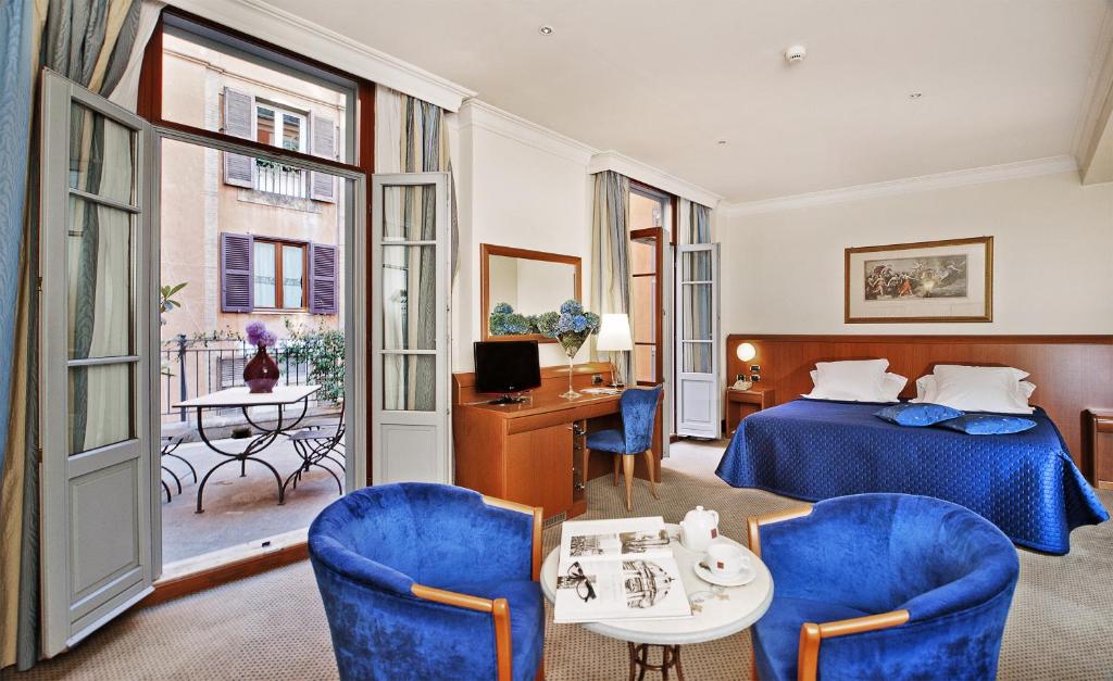Una habitación de hotel con una cama, una mesa y sillas. en Hotel Ponte Sisto, en Roma