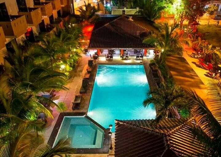 an overhead view of a swimming pool with palm trees at Cocco Resort in Pattaya South