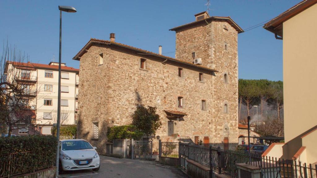 a car parked in front of a large stone building at Little Room - Camera indipendente nella Torre in Pontassieve