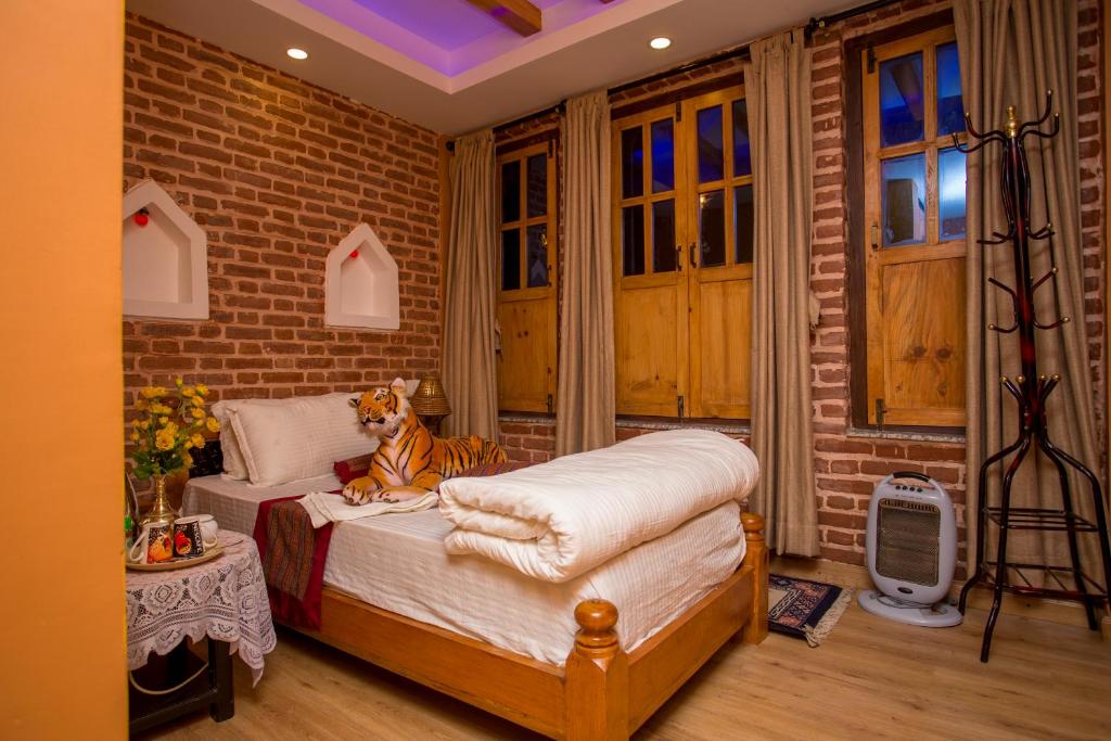a room with a bed with a tiger sitting on it at Blue Mountain Home Stay in Kathmandu
