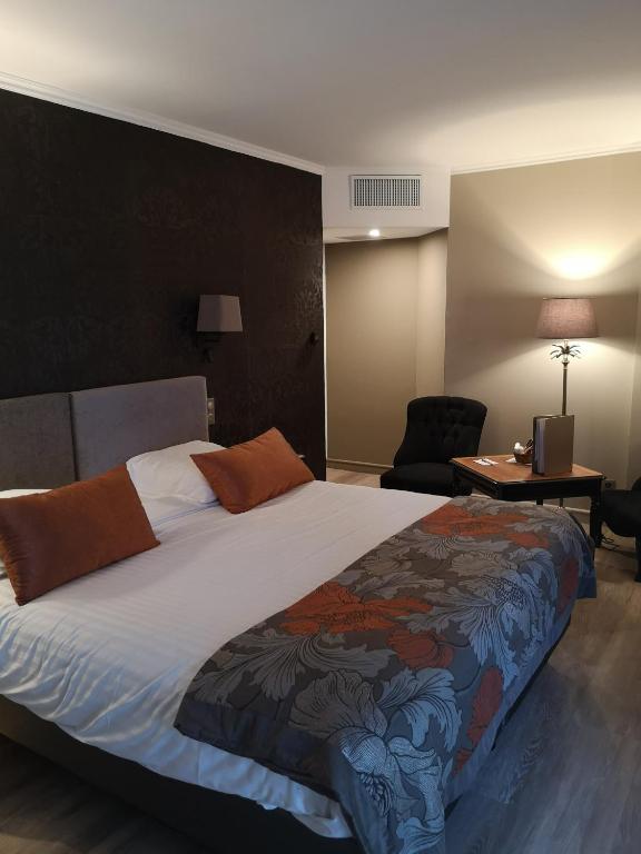a bedroom with a bed and a desk and a chair at Villa Augeval Hôtel de charme & Spa in Deauville