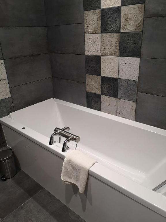 a bathroom with a bath tub with a towel on it at Villa Augeval Hôtel de charme & Spa in Deauville