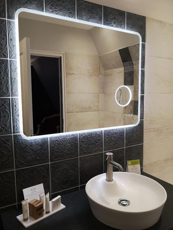 a bathroom with a sink and a mirror at Villa Augeval Hôtel de charme & Spa in Deauville
