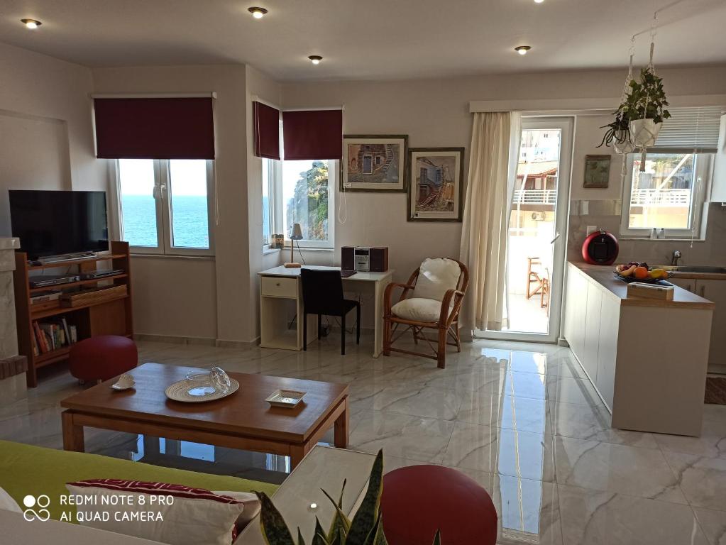 アギア・ペラギアにあるPopis Sea View Apartmentsのリビングルーム(ソファ、テーブル付)