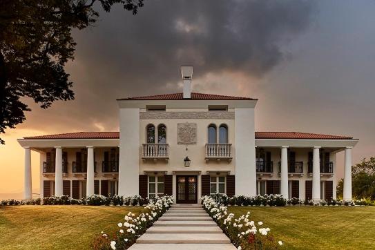 a large white building with a lawn with flowers at Villa Maria Vittoria in Nervesa della Battaglia
