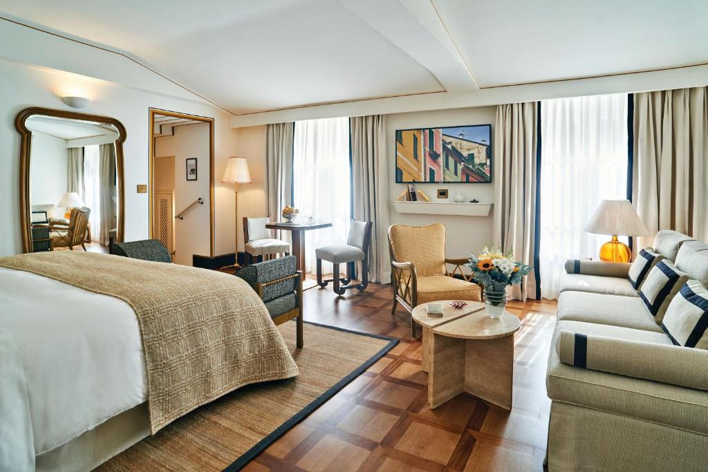a hotel room with a bed and a living room at Splendido Mare, A Belmond Hotel, Portofino in Portofino