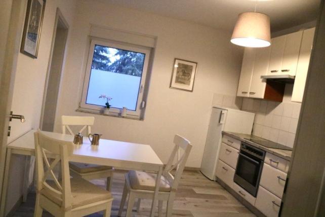 een keuken met een tafel en stoelen en een raam bij Ferienwohnung Lipizzaner in Neußen