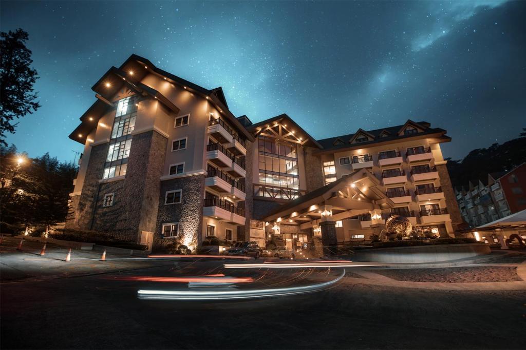 um grande edifício com luzes acesas à noite em Azalea Residences Baguio em Baguio