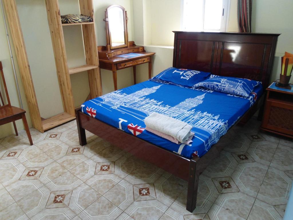 um quarto com uma cama com um edredão azul em Chambres D'hôtes AISSA em Saint-Denis