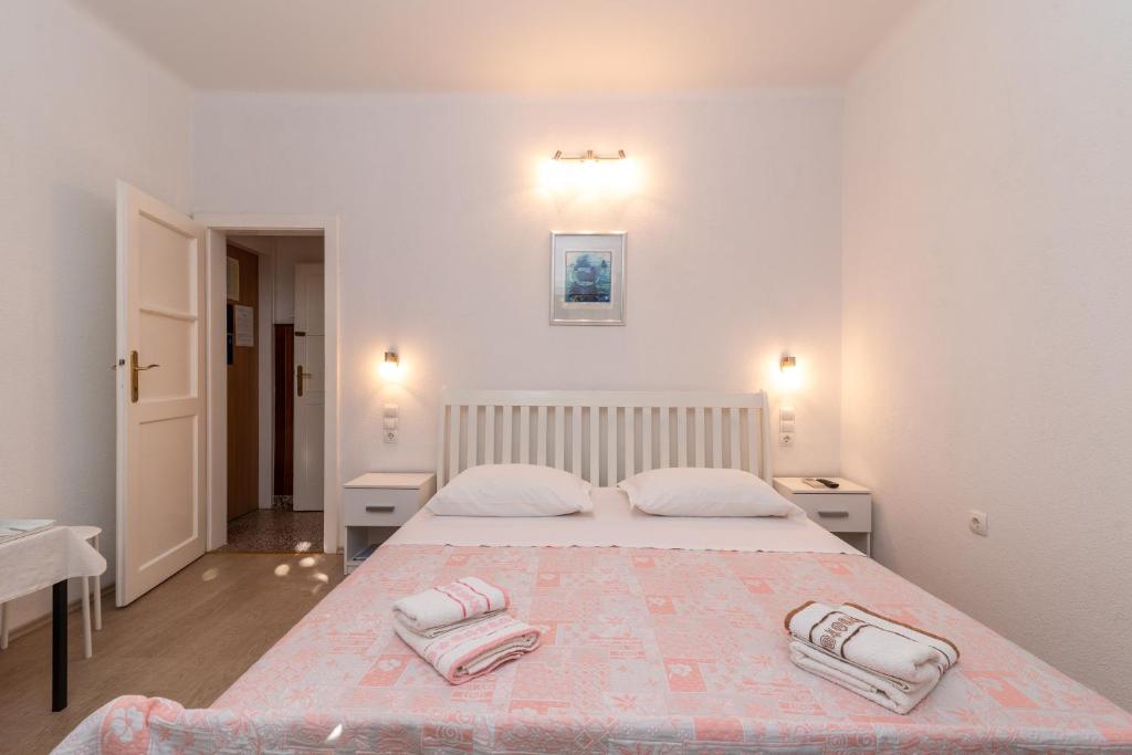 a bedroom with a bed with two towels on it at Rooms Feme in Trogir