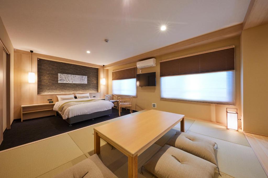 a hotel room with a bed and a table at Rinn Shirakawa South in Kyoto