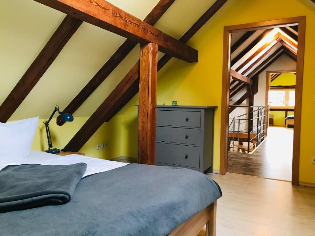 ein Schlafzimmer mit gelben Wänden, einem Bett und einer Treppe in der Unterkunft Landkulturhof Glücksbringer in Rudolstadt