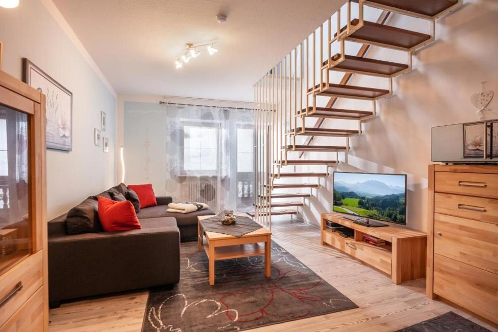 ein Wohnzimmer mit einem Sofa und einer Wendeltreppe in der Unterkunft Bergschlössl - Massionettwohnung 12 in Oberaudorf