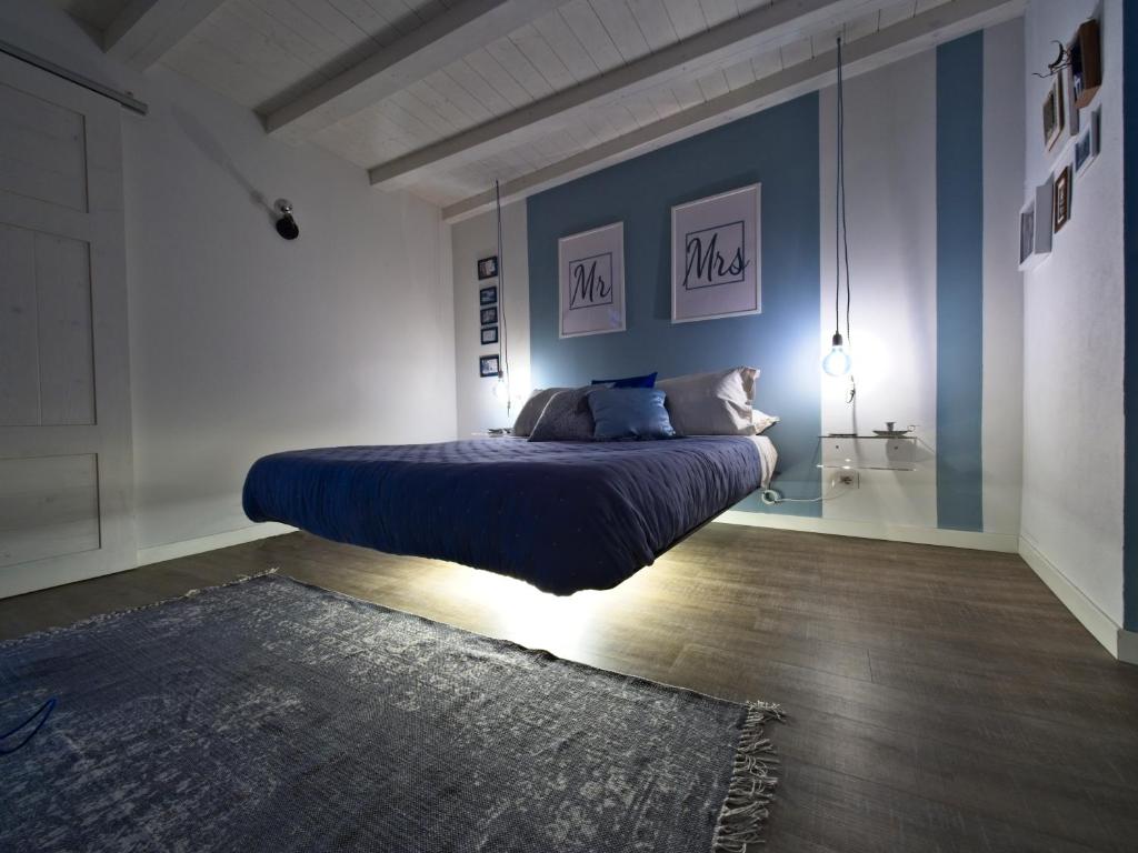 a bedroom with a bed with blue walls and a rug at Light Blue Lake Aria in Argegno