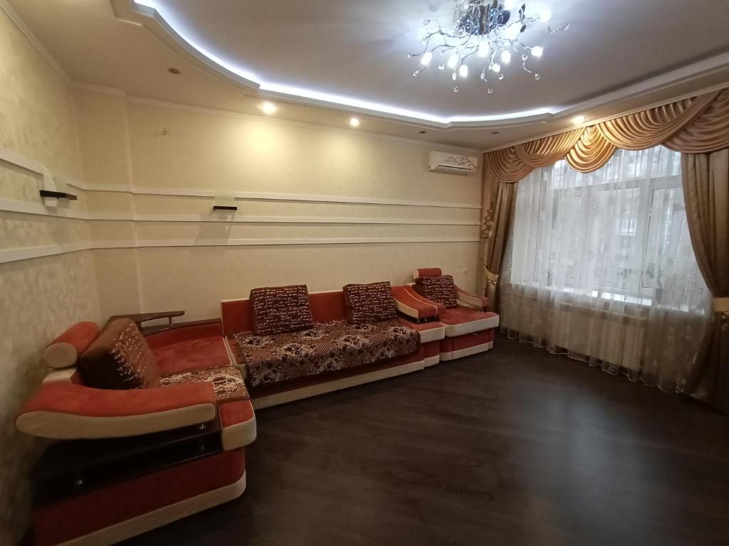 een woonkamer met banken en een kroonluchter bij Квартира на Данилевского in Charkov