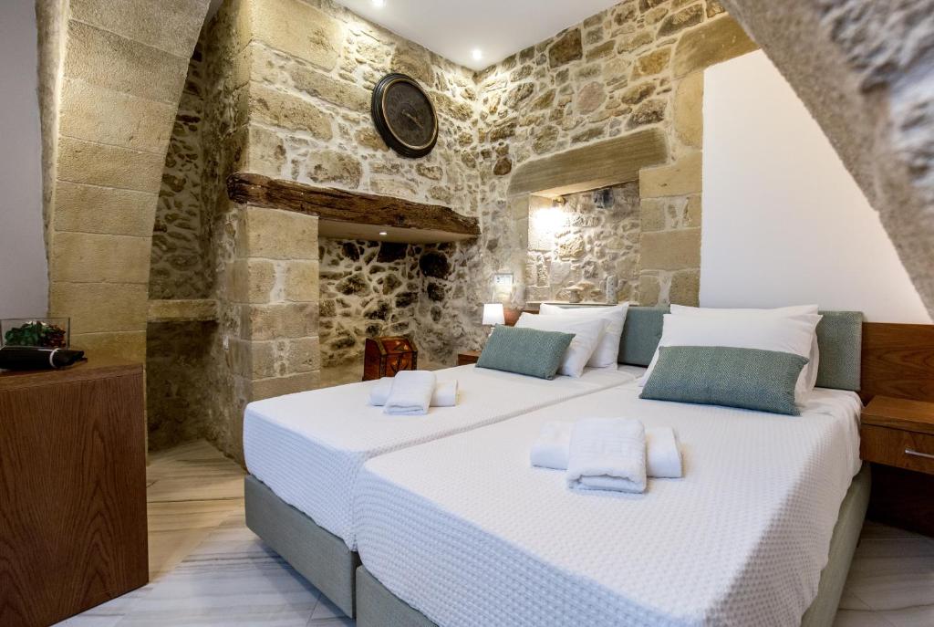 a bedroom with a large bed in a stone wall at Agarathos Deluxe Homes In the Heart of Kaliviani Near Balos in Kissamos