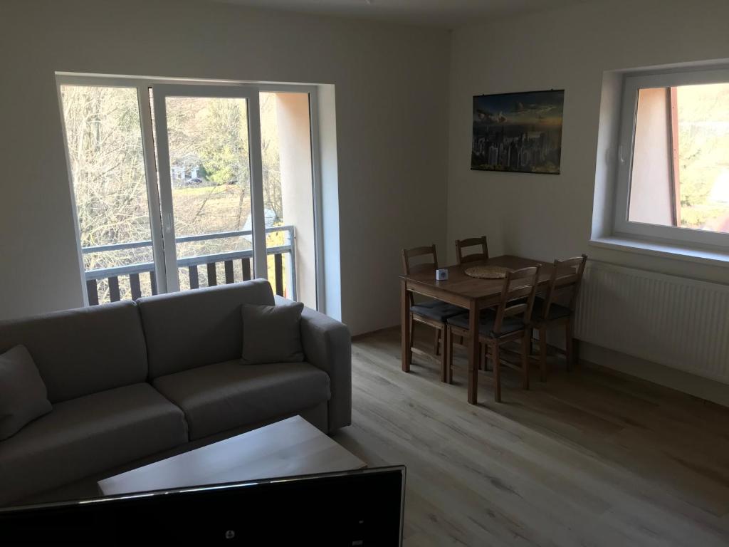 uma sala de estar com um sofá e uma mesa em Apartmán Horní Lipová em Ober Lindewiese