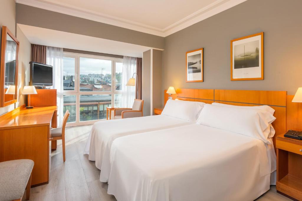 a hotel room with a large white bed and a window at Hotel San Sebastián Orly, Affiliated by Meliá in Donostia-San Sebastián