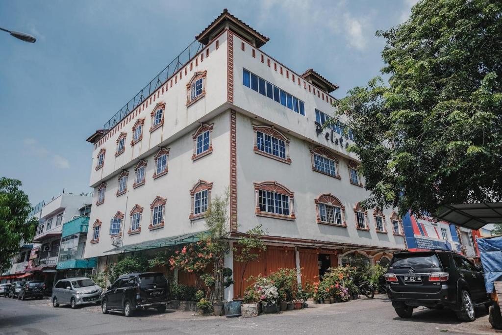 a large white building with cars parked in front of it at Reddoorz near Nagoya Hill Mall Batam 5 in Batam Center