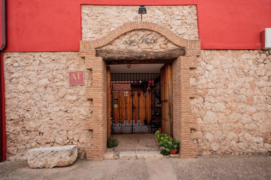 una entrada a un edificio de ladrillo con una puerta en Los Nidos de Rebollosa en Rebollosa de Hita