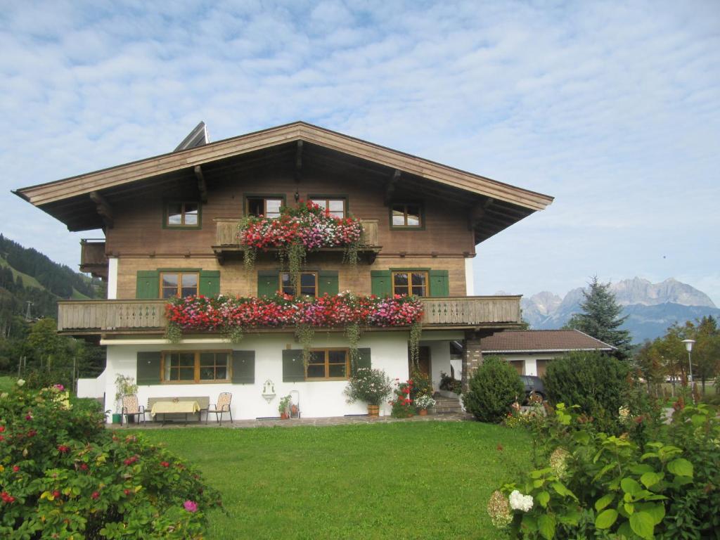 ein großes Haus mit Blumen davor in der Unterkunft Haus Friedl in Kitzbühel